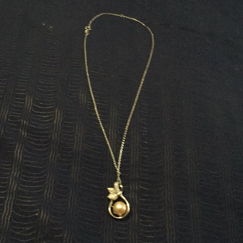 Necklace with a pink pearl.